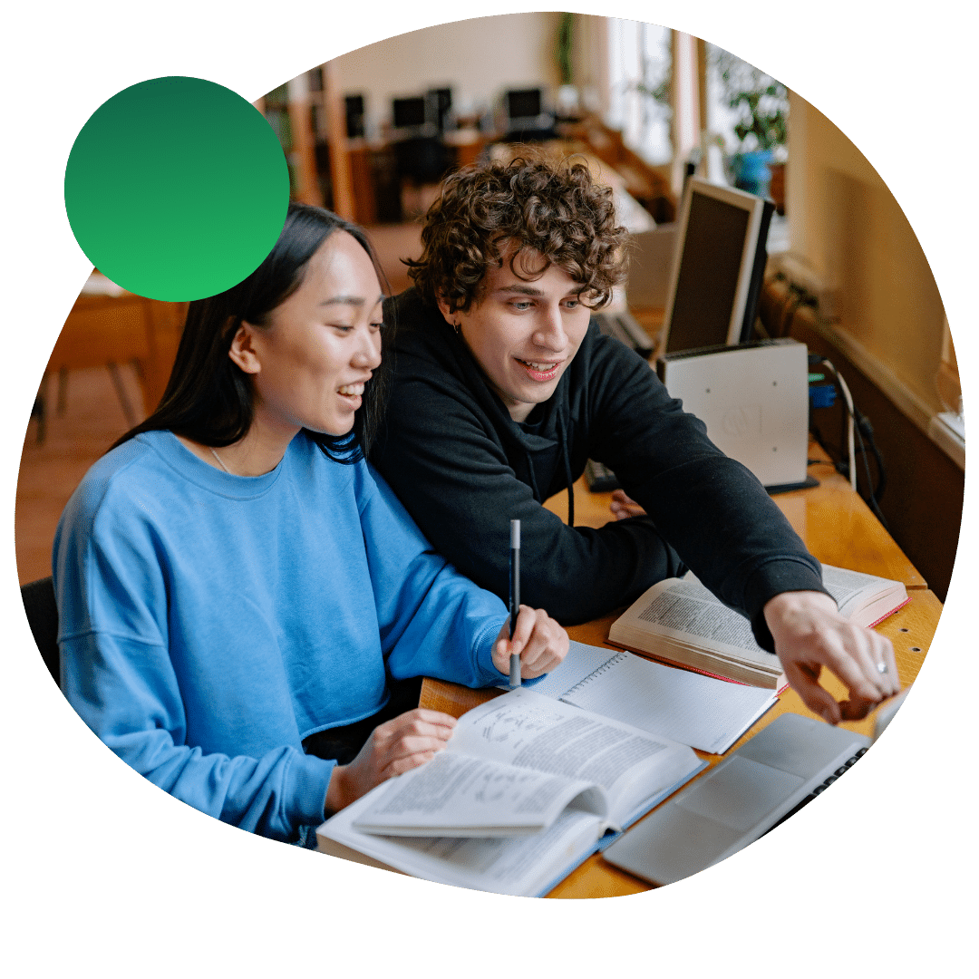 College students working on a laptop and studying notes for their upcoming test