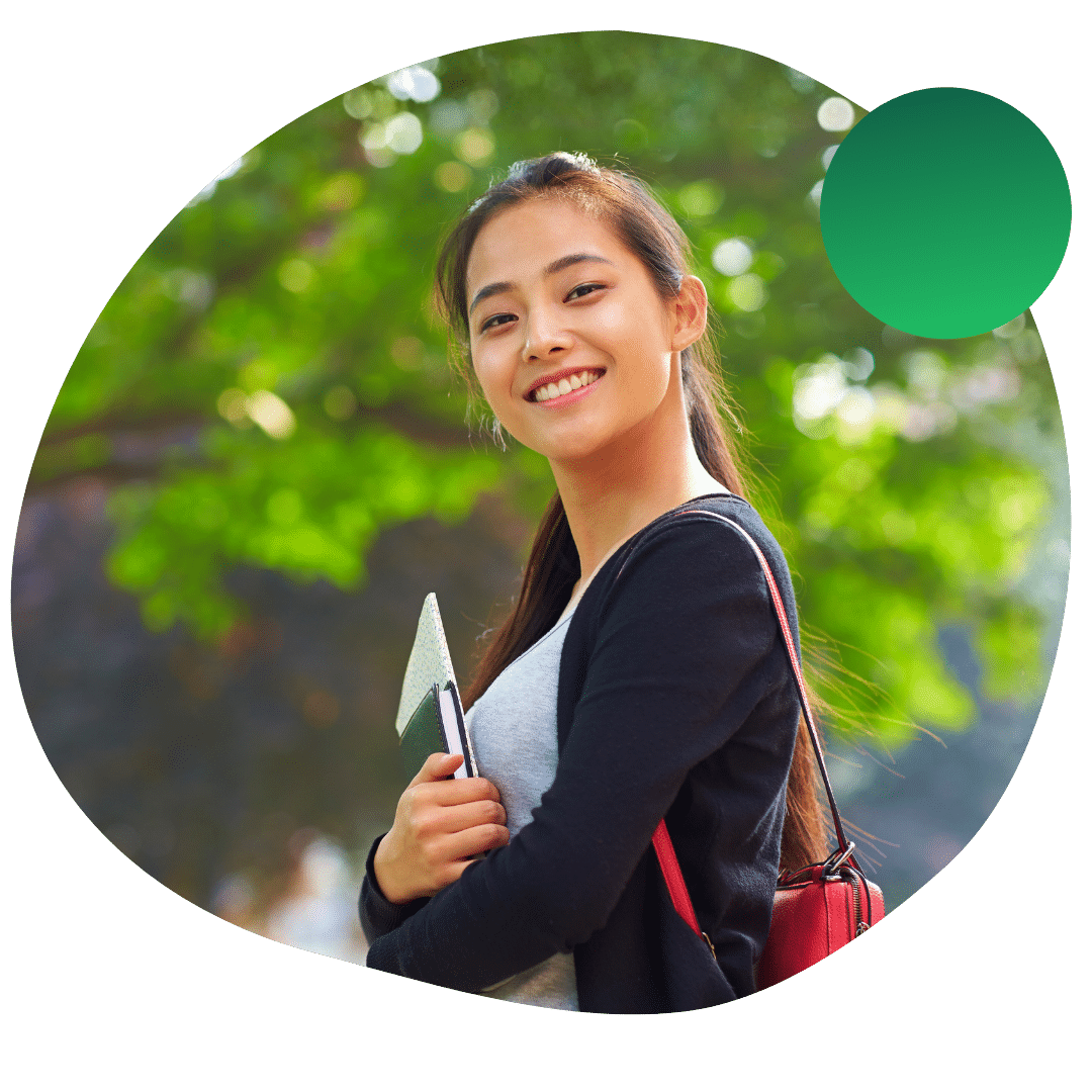Transfer student smiling and holding books on UChicago's campus